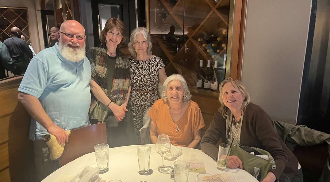 Barbara and friends smile around the dinner table
