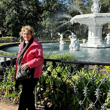 Kathryn stands in front of a white fountain