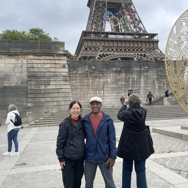 Fumie and Ahmed stand in front of the Eiffel Tower