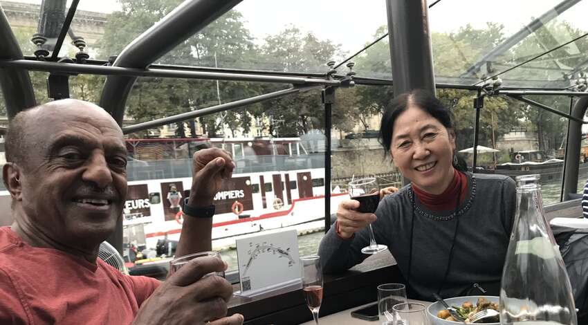 Fumie and Ahmed raise their glasses at a meal in France