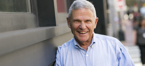 Mike Zoob smiles at the camera while leaning against a building